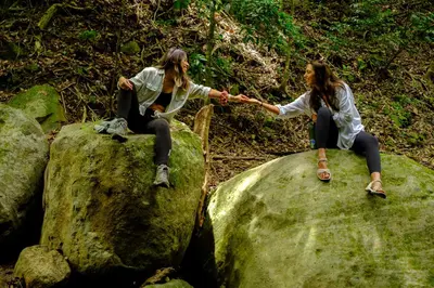 two women sitting on some rocks holding hands at Casa Coyota Hotel in Monteverde Costa Rica