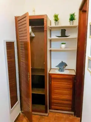 a closet with a wooden door and a shelf at Habitación privada en La Sabana in San José