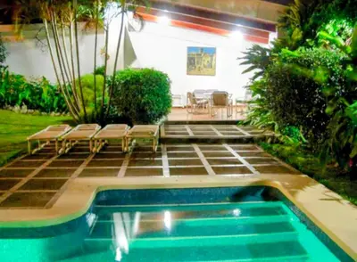 a swimming pool with lounge chairs and a patio at Habitación privada en La Sabana in San José