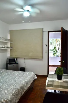 a bedroom with a bed and a table and a projector at Habitación privada en La Sabana in San José