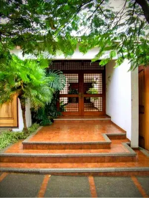 a front door of a building with stairs leading to it at Habitación privada en La Sabana in San José
