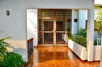 an open door of a house with plants at Habitación privada en La Sabana in San José