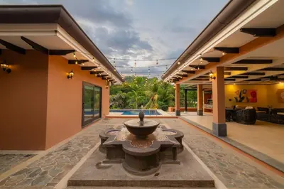 a courtyard with a fountain in the middle of a house at Casa Plazoleta 4 bdr private pool in Los Suenos in Herradura