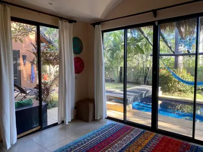 a room with sliding glass doors and a swimming pool at Casa Clancy in Tamarindo