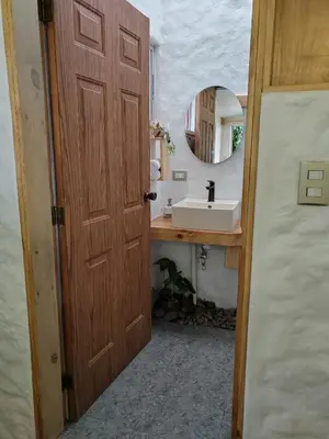 a bathroom with a wooden door and a sink at Apartamento Agapanto, descanso, ocio o trabajo in La Asunción