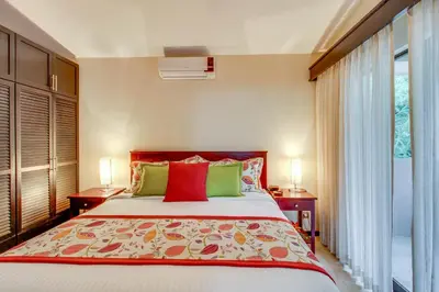 a bedroom with a bed with two lamps and a window at The Cove 7/8 at Playa Ocotal in Ocotal