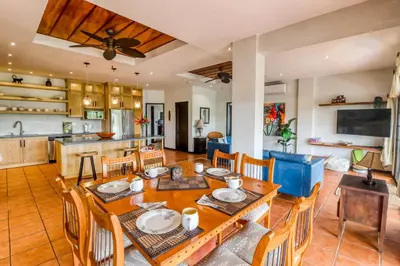 a dining room and kitchen with a table and chairs at Casa Mimosa Buenavista in Playa Flamingo