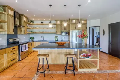 a kitchen with a large island with two bar stools at Casa Mimosa Buenavista in Playa Flamingo