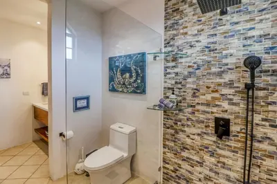 a bathroom with a toilet and a brick wall at Casa Mimosa Buenavista in Playa Flamingo