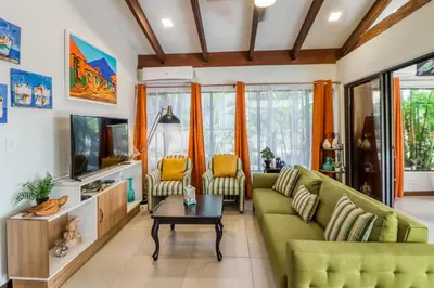 a living room with a green couch and a tv at Villa Sol 36 in Playa Hermosa