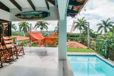 a villa with a swimming pool and palm trees at Villa Sol 36 in Playa Hermosa