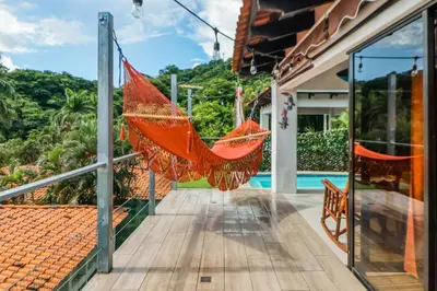 an orange hammock hanging from a porch of a house at Villa Sol 36 in Playa Hermosa