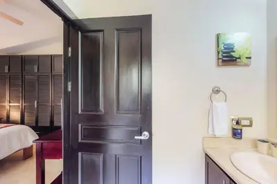 a bathroom with a black door and a sink at The Cove 5/6 at Playa Ocotal in Ocotal