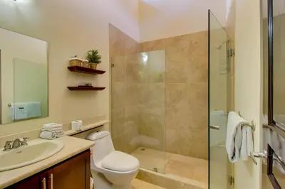 a bathroom with a shower and a toilet and a sink at The Cove 5/6 at Playa Ocotal in Ocotal