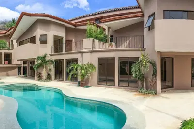 a house with a swimming pool in front of it at The Cove 5/6 at Playa Ocotal in Ocotal