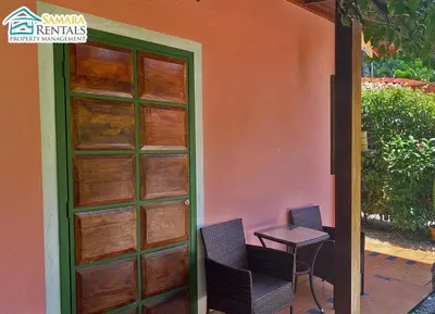a patio with two chairs and a table next to a door at Cozy Apartment Downtown in Nicoya