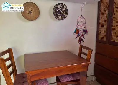 a wooden table with two chairs and a wall at Cozy Apartment Downtown in Nicoya