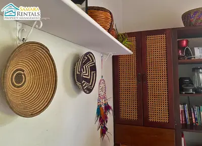 a wall with two hats and a shelf with baskets at Cozy Apartment Downtown in Nicoya
