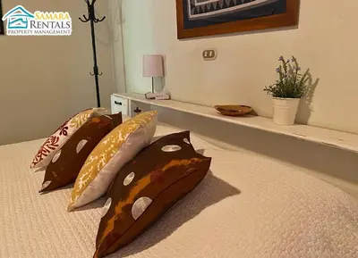 a bed with four pillows on it with at Cozy Apartment Downtown in Nicoya