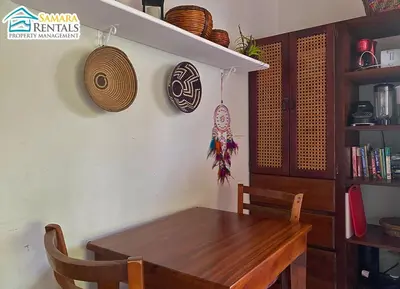 a dining room with a wooden table and a shelf at Cozy Apartment Downtown in Nicoya