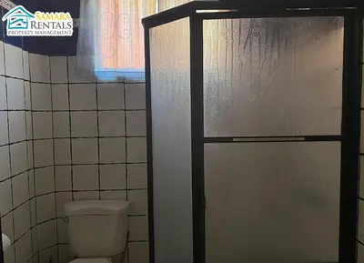a bathroom with a toilet and a glass shower door at Cozy Apartment Downtown in Nicoya