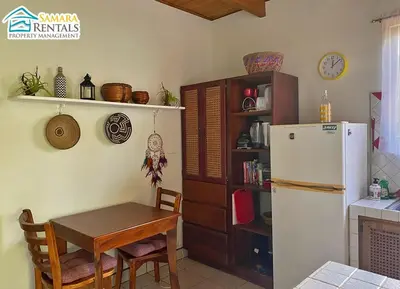 a kitchen with a table and a white refrigerator at Cozy Apartment Downtown in Nicoya