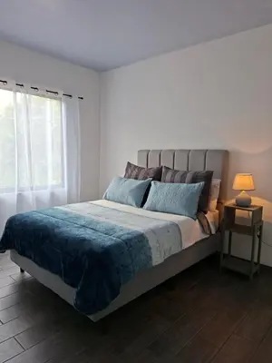 a bedroom with a bed with a blue blanket and a window at Villa Kaza Proyecto in Santa María