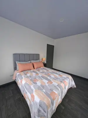 a bedroom with a large bed with orange pillows at Villa Kaza Proyecto in Santa María