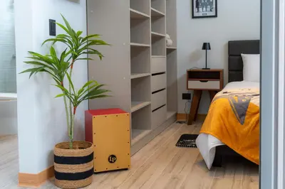 a bedroom with a plant in a yellow box next to a bed at Sakura Haus in Turrialba
