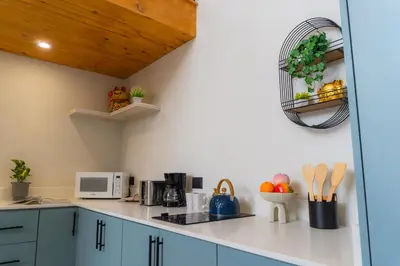a kitchen with blue cabinets and a white counter top at Sakura Haus in Turrialba