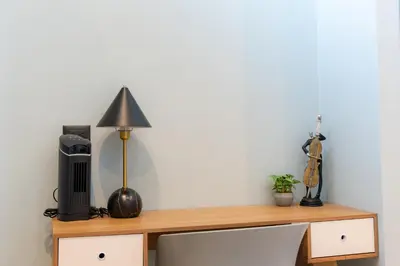 a wooden shelf with a lamp and a television on it at Sakura Haus in Turrialba