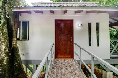 a small white house with a wooden door at Pools Bungalow at Toucan in Coronado