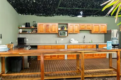 a kitchen with wooden cabinets and a large wooden table at Tortuga HBH in Playa Hermosa