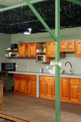 a kitchen with wooden cabinets and a green pole at Tortuga HBH in Playa Hermosa