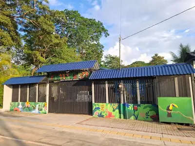 a building with a blue roof with graffiti on it at Deer Apartments Bahía Ballena in Uvita