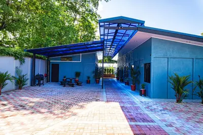 a blue building with a blue roof and a patio at Deer Apartments Bahía Ballena in Uvita