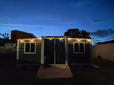 a tiny house with lights on it at night at contenedor estudio in Tilarán