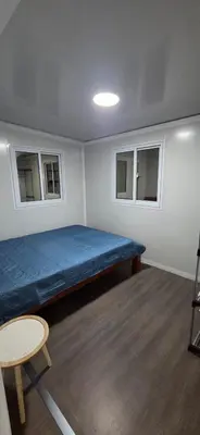 a small room with a bed and two windows at contenedor estudio in Tilarán