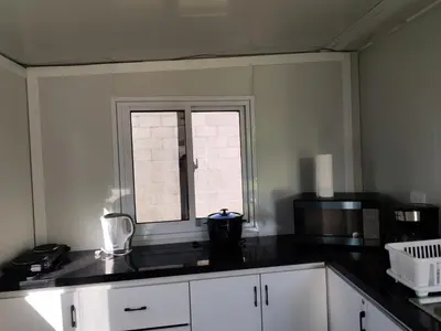 a kitchen with a black counter top and a window at contenedor estudio in Tilarán