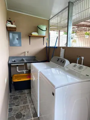 a laundry room with a washing machine and a sink at Vacation Home with Pool Quepos in Quepos