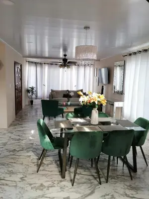 a dining room with a table and green chairs at Vacation Home with Pool Quepos in Quepos