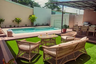 a patio with chairs and a table and a pool at Vacation Home with Pool Quepos in Quepos
