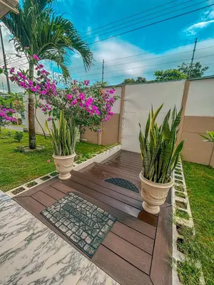 a wooden deck with two potted plants on it at Vacation Home with Pool Quepos in Quepos