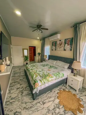 a bedroom with a large bed and a ceiling fan at Vacation Home with Pool Quepos in Quepos