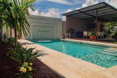 a swimming pool in front of a house at Vacation Home with Pool Quepos in Quepos