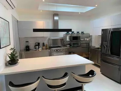 a large kitchen with a counter and chairs in it at Backyard Beach House Oceanfront Luxury 5 Bdr in Playa Hermosa