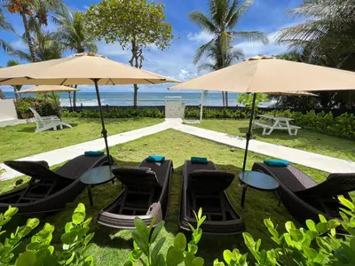 a group of tables and chairs under umbrellas at Backyard Beach House Oceanfront Luxury 5 Bdr in Playa Hermosa