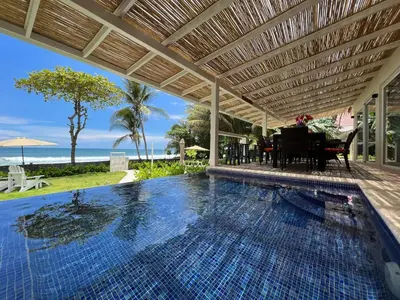 a swimming pool with a pergola and the ocean at Backyard Beach House Oceanfront Luxury 5 Bdr in Playa Hermosa