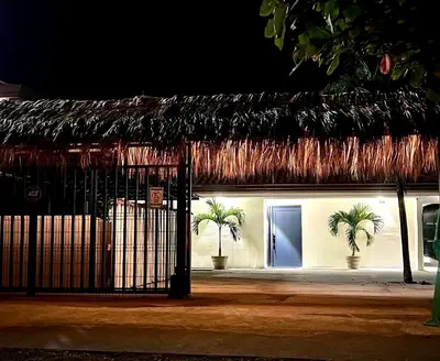a building with a gate with palm trees in front of it at Backyard Beach House Oceanfront Luxury 5 Bdr in Playa Hermosa