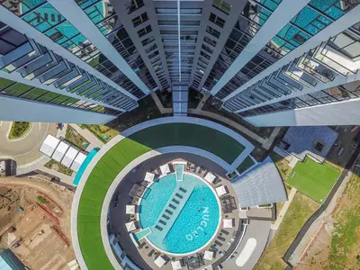 an overhead view of a building with a swimming pool at Modern Condo in Núcleo La Sabana with Pool in San José